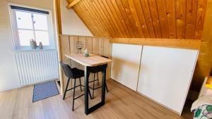 uma pequena cozinha com uma mesa e um frigorífico num quarto em Studio Burg.bosselaarstraat em Aagtekerke