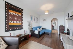 uma sala de estar com um sofá azul e uma mesa em Terrace Vila by An Island Apart no Caniço