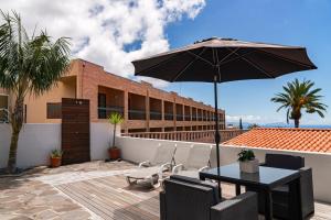 une terrasse avec une table et un parasol dans l'établissement Terrace Vila by An Island Apart, à Caniço