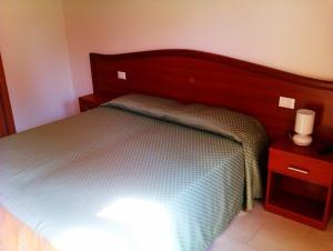 una camera con letto e testata in legno di Agriturismo la Chioccia a Campagna Lupia