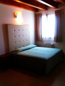 Dormitorio pequeño con cama y ventana en Agriturismo la Chioccia en Campagna Lupia