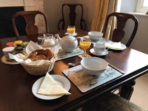 a dining room table with a table set with food and drinks at Tregiffian Farm B&B in Penzance