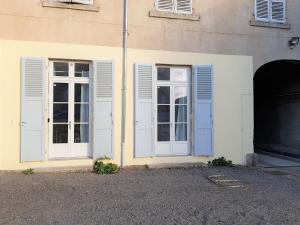 - un bâtiment blanc avec des fenêtres blanches et une porte dans l'établissement Issoire centre, T2 Bergère avec parking, à Issoire