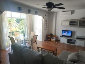 a living room with a couch and a table and a tv at CARABEO I 18 MENYBER in Nerja