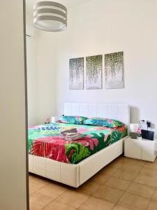 una camera da letto con un letto bianco e una coperta colorata di Maiden-Art Apartment ad Arona