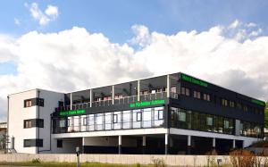 a white building with green words on it at Motel am Fürfelder Schloss in Bad Rappenau