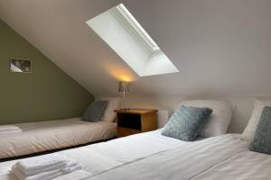 Zimmer im Dachgeschoss mit 2 Betten und einem Dachfenster in der Unterkunft Authentic Stays - 5p-apartment in Eijsden