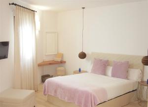 a bedroom with a large white bed with purple pillows at Hotel Abaco Altea in Altea