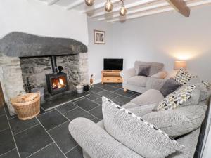 sala de estar con chimenea y sofás en Garreg Lwyd, en Blaenau Ffestiniog