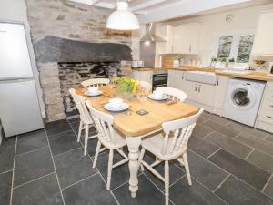 cocina con mesa de madera y electrodomésticos blancos en Garreg Lwyd, en Blaenau Ffestiniog