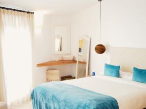 a bedroom with a large bed with blue pillows at Hotel Abaco Altea in Altea
