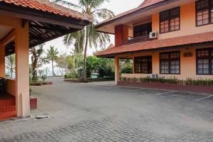 un cortile vuoto di un edificio con palme di RedDoorz Plus near Tugu Mercusuar Anyer a Serang