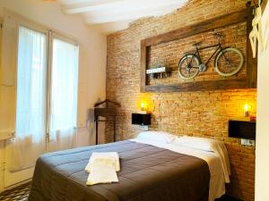 - une chambre avec un lit et un vélo sur le mur dans l'établissement Hostal Portugal, à Barcelone