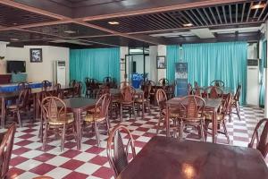 una sala da pranzo con tavoli e sedie di RedDoorz Plus near Tugu Mercusuar Anyer a Serang