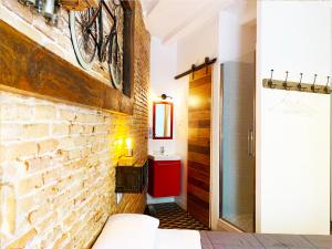 バルセロナにあるHostal Portugalのレンガの壁のベッドルーム1室(壁に自転車付)