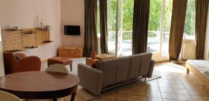 ein Wohnzimmer mit einem Sofa und einem Tisch in der Unterkunft Bacchus - helles und geräumiges Appartement am Rande von Mainz in Mainz