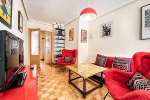 salon z czerwonymi meblami i stołem w obiekcie Magnifico apartamento en el centro de Oviedo w mieście Oviedo