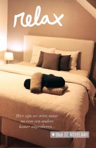 A bed or beds in a room at B&B De Notelaar