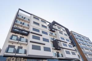 a tall white apartment building with blue windows at Avenue Suites Hotel in Casablanca