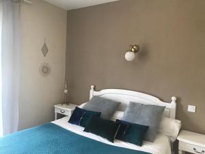 een slaapkamer met een wit bed met blauwe kussens bij L'acqua Viva in Calacuccia