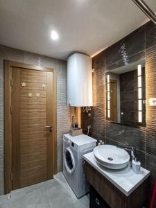 a bathroom with a washing machine and a sink at Apartman Relax Lux - Vila Peković in Zlatibor