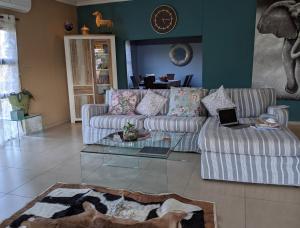 a living room with a couch and a glass table at The Residence Chobe Villa in Kasane