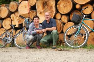 Dois homens estão sentados ao lado de duas motos. em Na Wysokiej Górce- Agroturystyka em Grabowiec