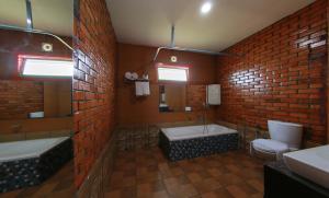 a bathroom with two sinks and a brick wall at Woodgreens Heritage Resorts in Kannur