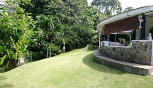 una casa con un patio de césped al lado de un edificio en The Reef Palm en Anse aux Pins