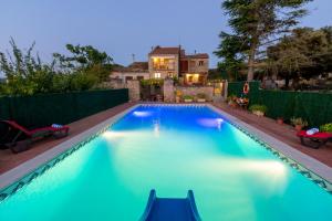 basen z niebieską wodą przed domem w obiekcie 8 to 10 Sleeps Private Pool Villa & BBQ Near Barcelona w mieście Rocafort