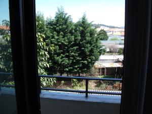 una ventana con vistas a un árbol en APART Alojamentos Para Turismo e Negocios, en Braga 2 fotos más