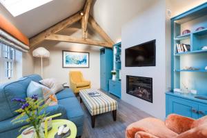 a living room with a blue couch and a fireplace at Wella 5 Star Gold Award Luxury Cottage in St Ives