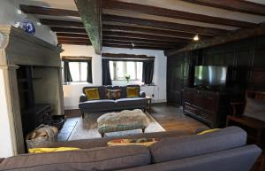 ein Wohnzimmer mit einem Sofa und einem TV in der Unterkunft Countersett Hall in Askrigg