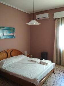- une chambre avec un lit blanc et un ventilateur dans l'établissement Two-Bedrooms Apartment in Center of Rethymno, à Réthymnon