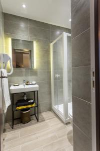 a bathroom with a sink and a shower at Pratic Hotel in Paris