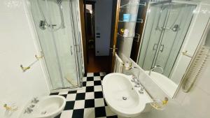 a bathroom with two sinks and a shower at Romantik Hotel Monteriggioni in Monteriggioni