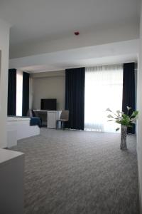 Una habitación de hotel con una sala de espera con un escritorio. en Glass Cube Hotel, en Chişinău