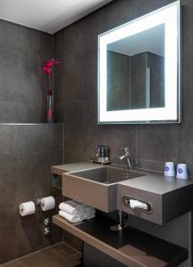 
a bathroom with a sink and a mirror at Novotel The Hague World Forum in The Hague
