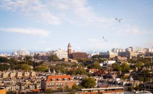 eine Stadt mit Gebäuden und Vögeln, die am Himmel fliegen in der Unterkunft Novotel The Hague World Forum in Den Haag