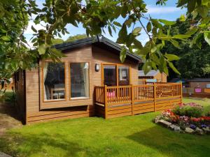 a tiny house with a deck and a porch at St. Ives Holiday Village in St Ives