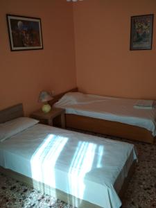 - une chambre avec deux lits et une table avec une lampe dans l'établissement Two-Bedrooms Apartment in Center of Rethymno, à Réthymnon