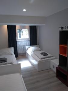 a white room with two beds and a window at City-Apartment Spreeufer im Herzen Berlins in Berlin