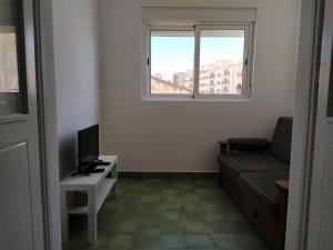 a living room with a couch and a table with a television at Urban Apartment in Faro