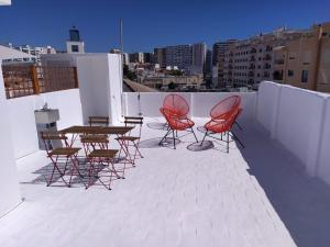 a patio with chairs and tables on a roof at Urban Apartment in Faro