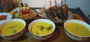 un plateau avec quatre bols de soupe et une assiette de nourriture dans l'établissement Bale Kembang Kuning, à Tetebatu