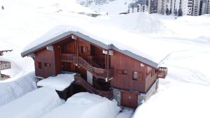un bâtiment recouvert de neige avec des escaliers enneigés dans l'établissement Chalet Le Grand Cap, à Tignes