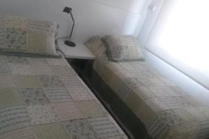 1 dormitorio con 2 camas y una lámpara en una mesa en Arenas del Mar, en Punta del Este