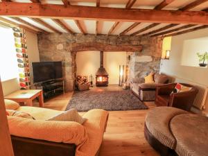 a living room with a couch and a fireplace at Llwyn Aethnen in Caernarfon