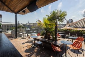 a patio with tables and chairs on a roof at BRYK Hotel - Maestro in Odesa