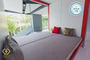 a large bed in a room with a window at Wake Up Aonang Hotel- SHA EXTRA PLUS in Ao Nang Beach